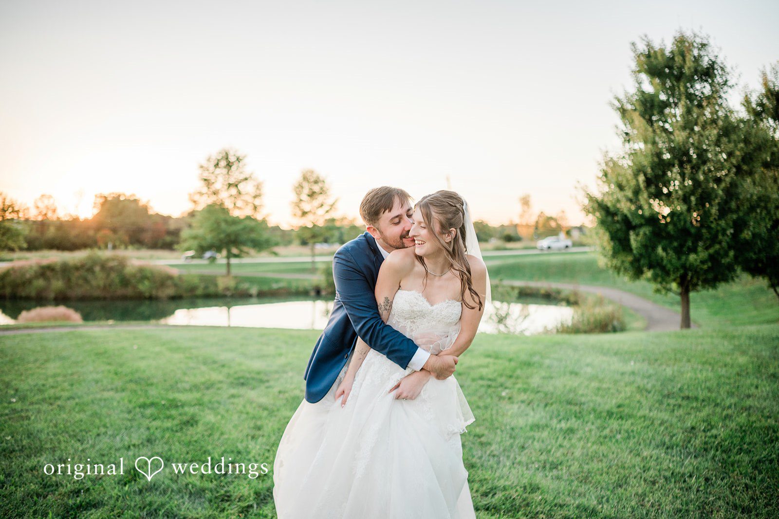 Kensey + Jordan Couple sharing a kiss at sunset by the pond at Muhlhauser Barn