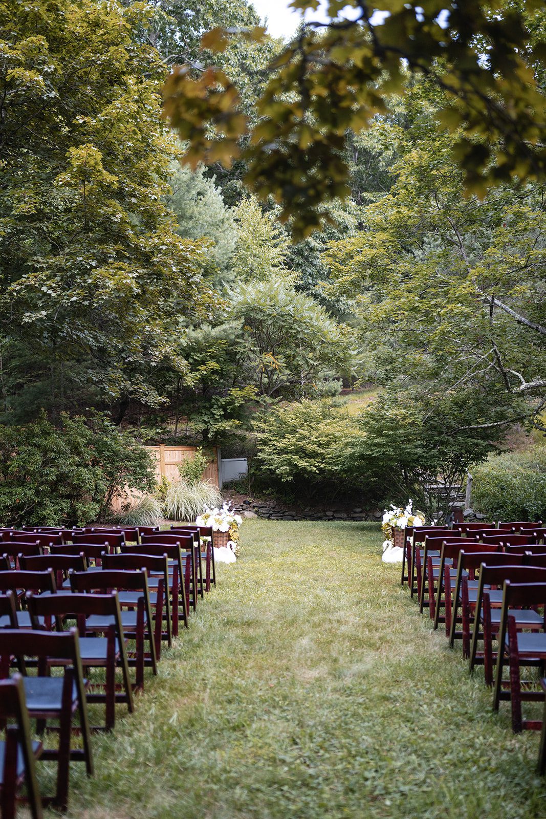 new-york-backyard-timeless-new-york-taylor-andrew-p001-22 Ceremony aisle lined with chairs at a New York backyard wedding