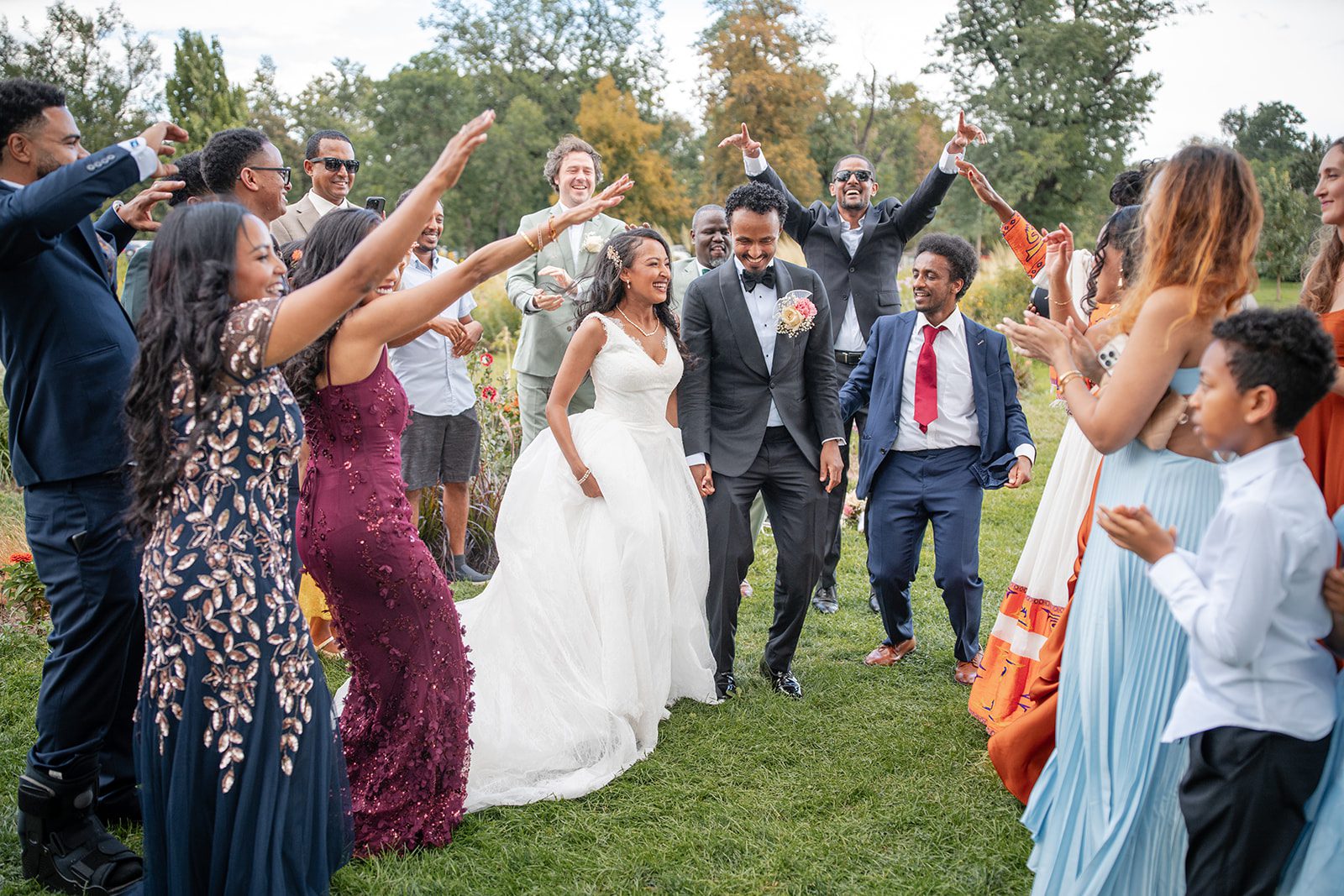 nuur-event-center-timeless-denver-henok-elshadaye-p024-16 Guests cheering around the newlyweds outdoors