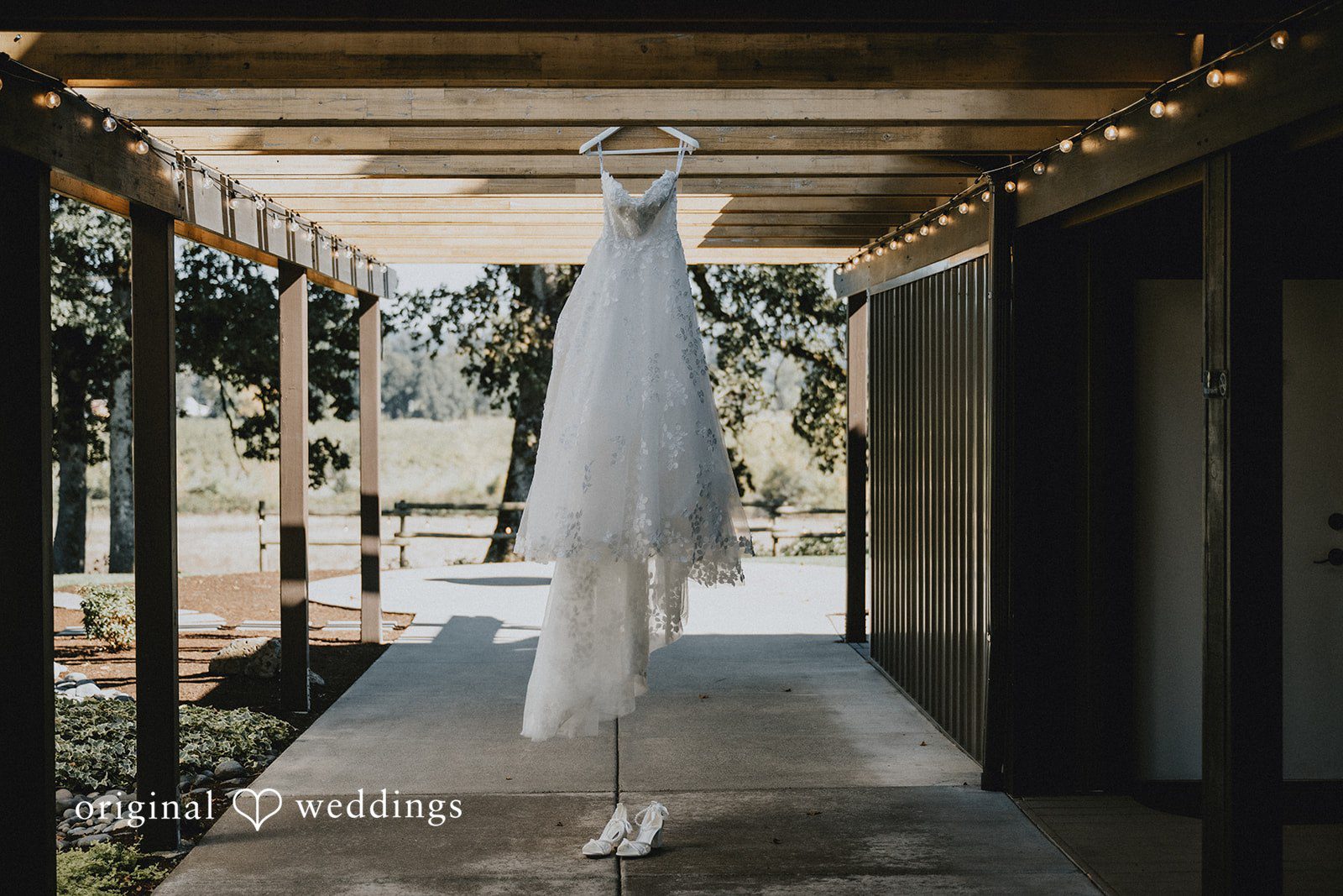 Wedding gown hanging in the barn at Oak & Hood