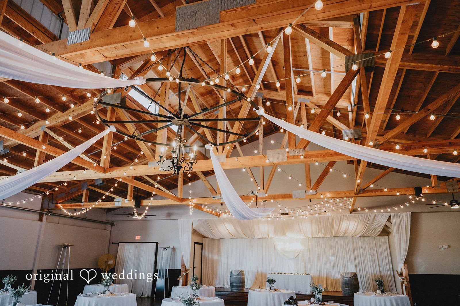 Barn reception hall with string lights at Oak & Hood