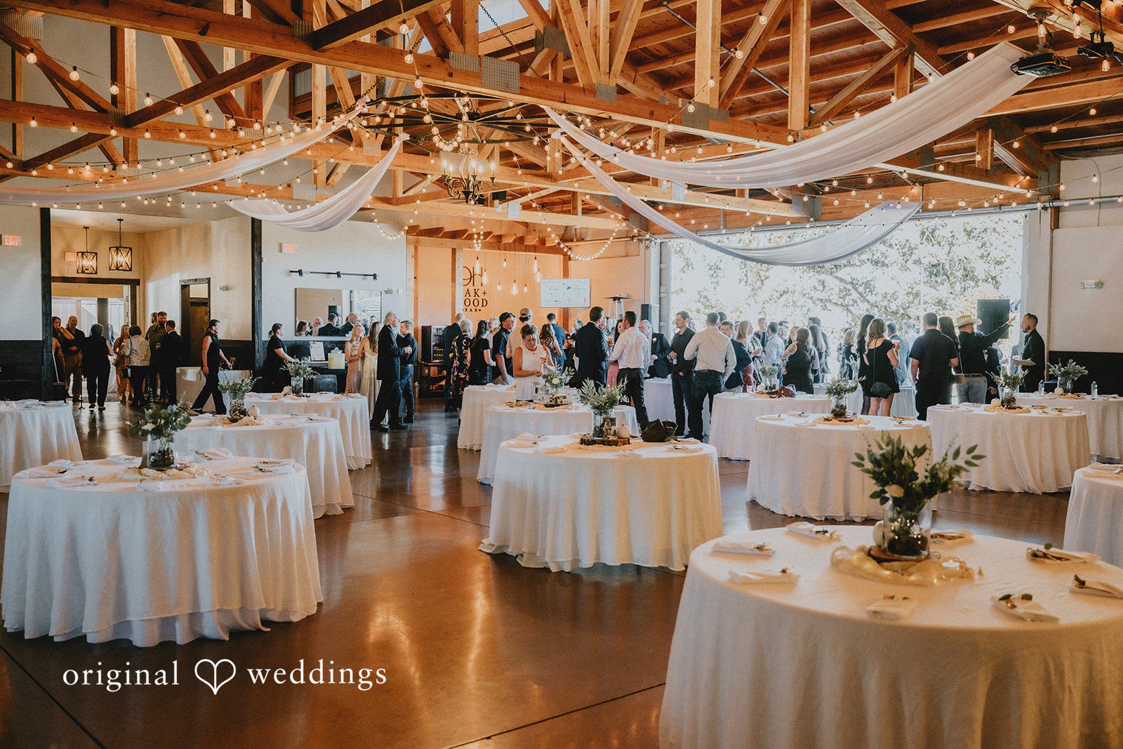 Reception tables set inside the barn at Oak & Hood