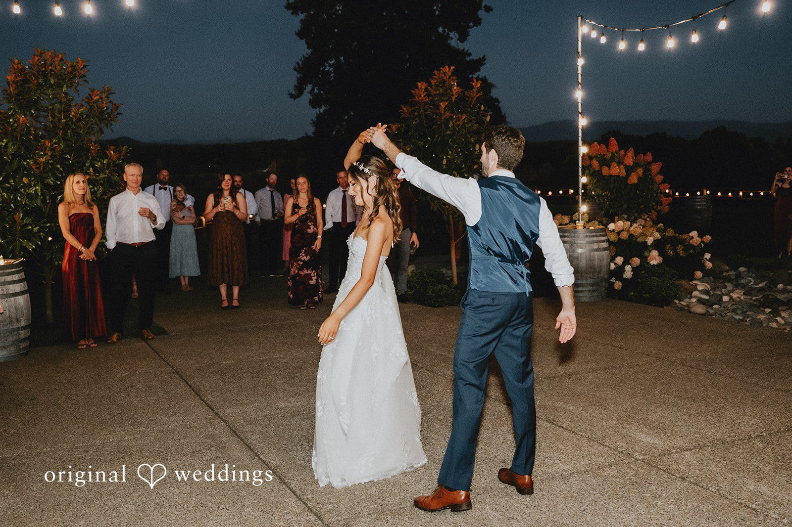 Couple sharing their first dance under the lights
