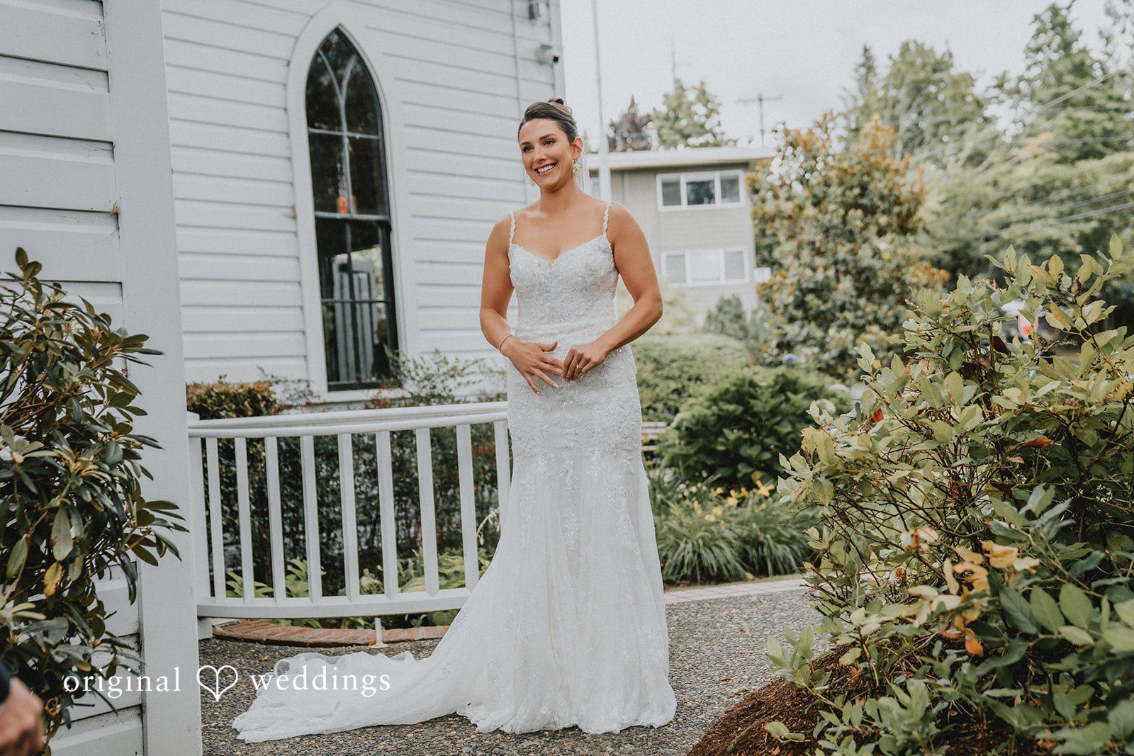 Ashley + Forrest A bride in a white wedding dress walks along a paved pathway next to a white railing.