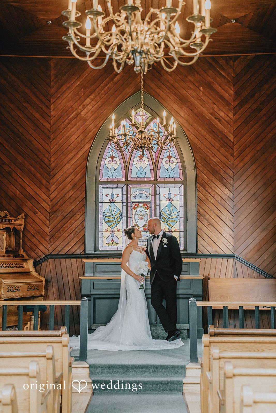 Ashley + Forrest A bride and groom standing at the altar inside a wood-paneled church.