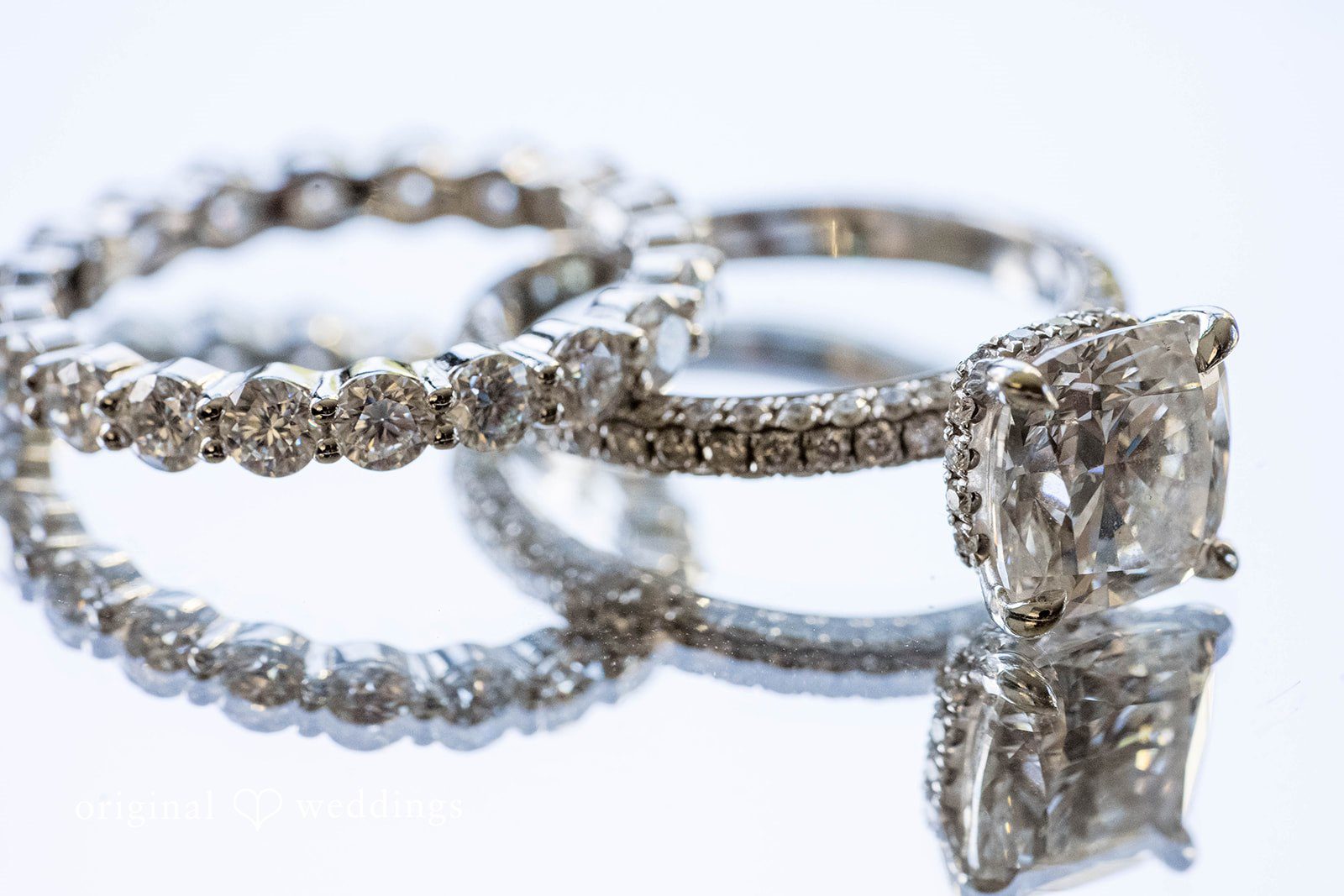 Brittany + Vincent Wedding rings on a white surface