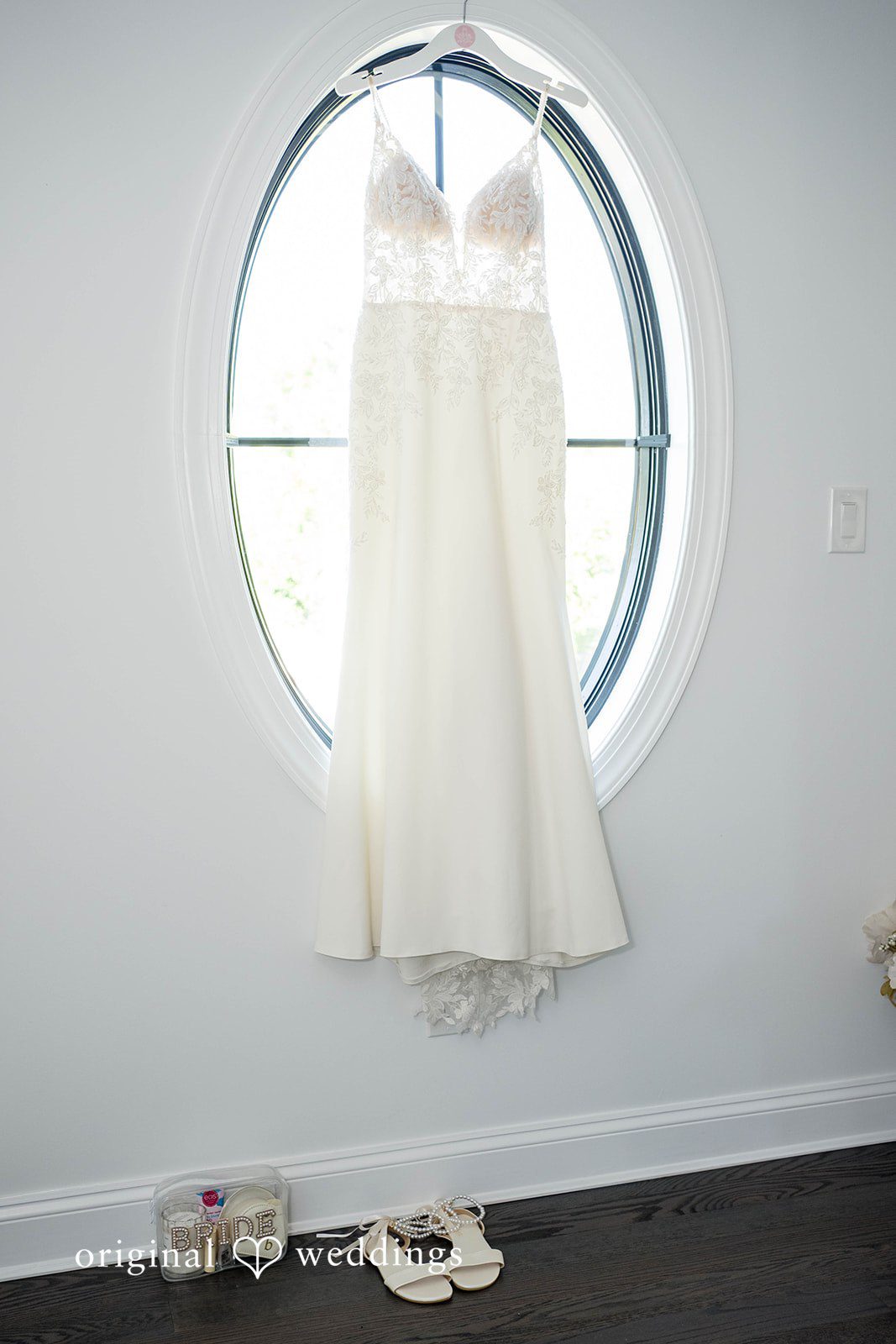 Brittany + Vincent Wedding dress hanging by a round window