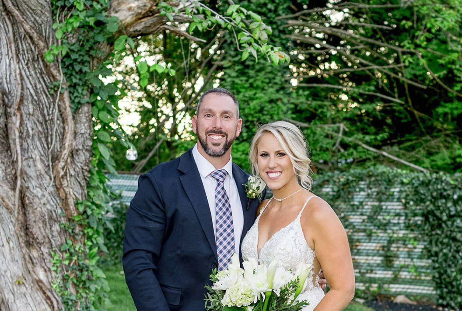 Bride and groom smiling together on the lawn, captured by Philadelphia wedding photographers from Original Weddings in a Pennsylvania backyard