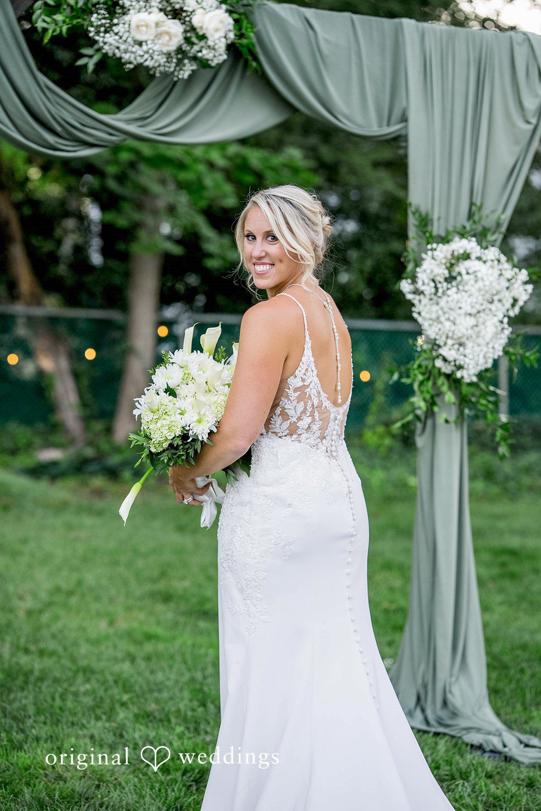 August 29, 2026 – Brittany & Vincent – (ID-5826) Bride smiling with her bouquet near the arch