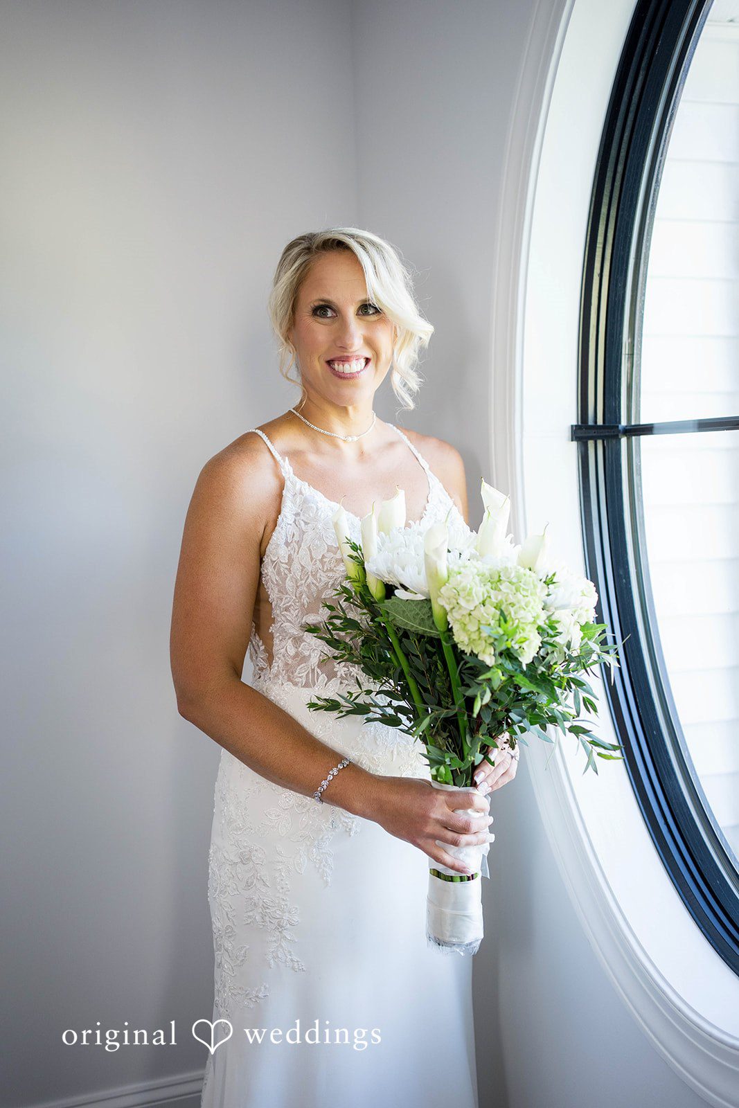 August 29, 2026 – Brittany & Vincent – (ID-5826) Bride holding her bouquet by a round window