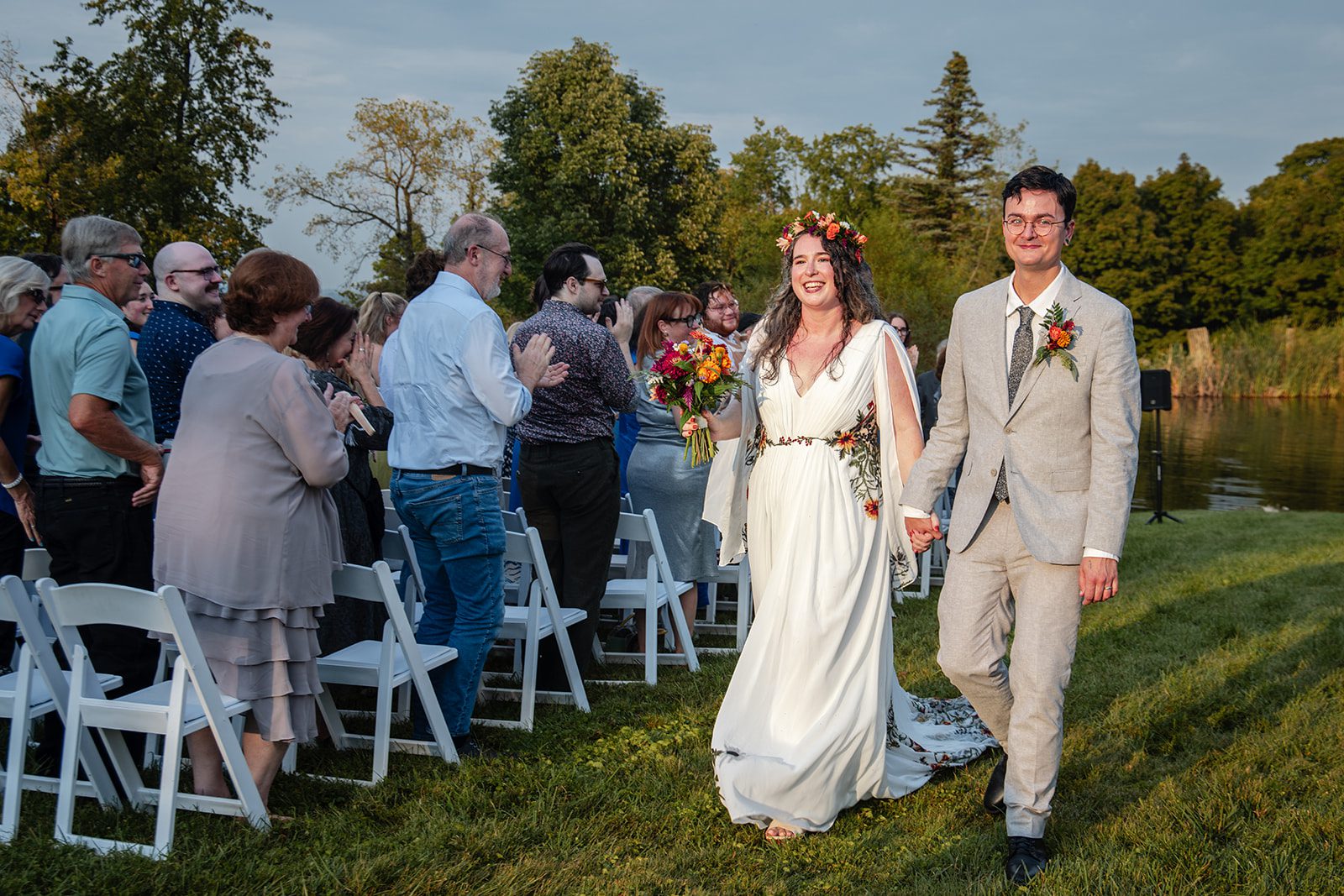 Bride and groom walking back up the aisle smiling, captured by Cincinnati wedding photographers from Original Weddings at Pyramid Hill Sculpture Park