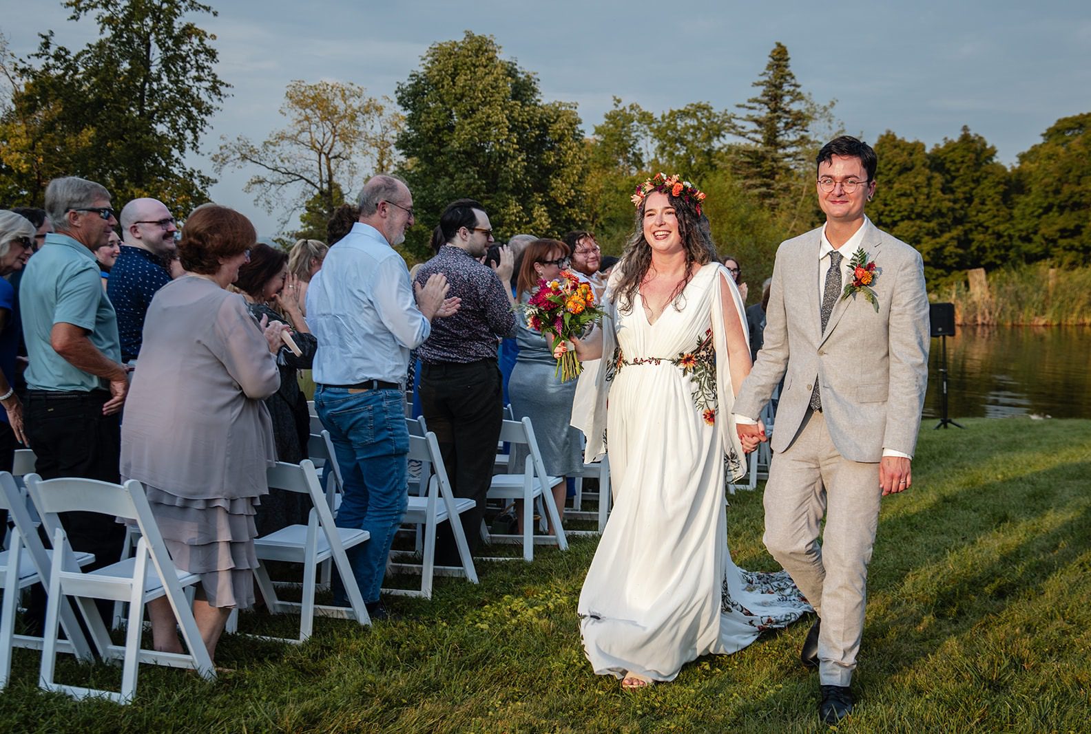Bride and groom walking back up the aisle smiling, captured by Cincinnati wedding photographers from Original Weddings at Pyramid Hill Sculpture Park