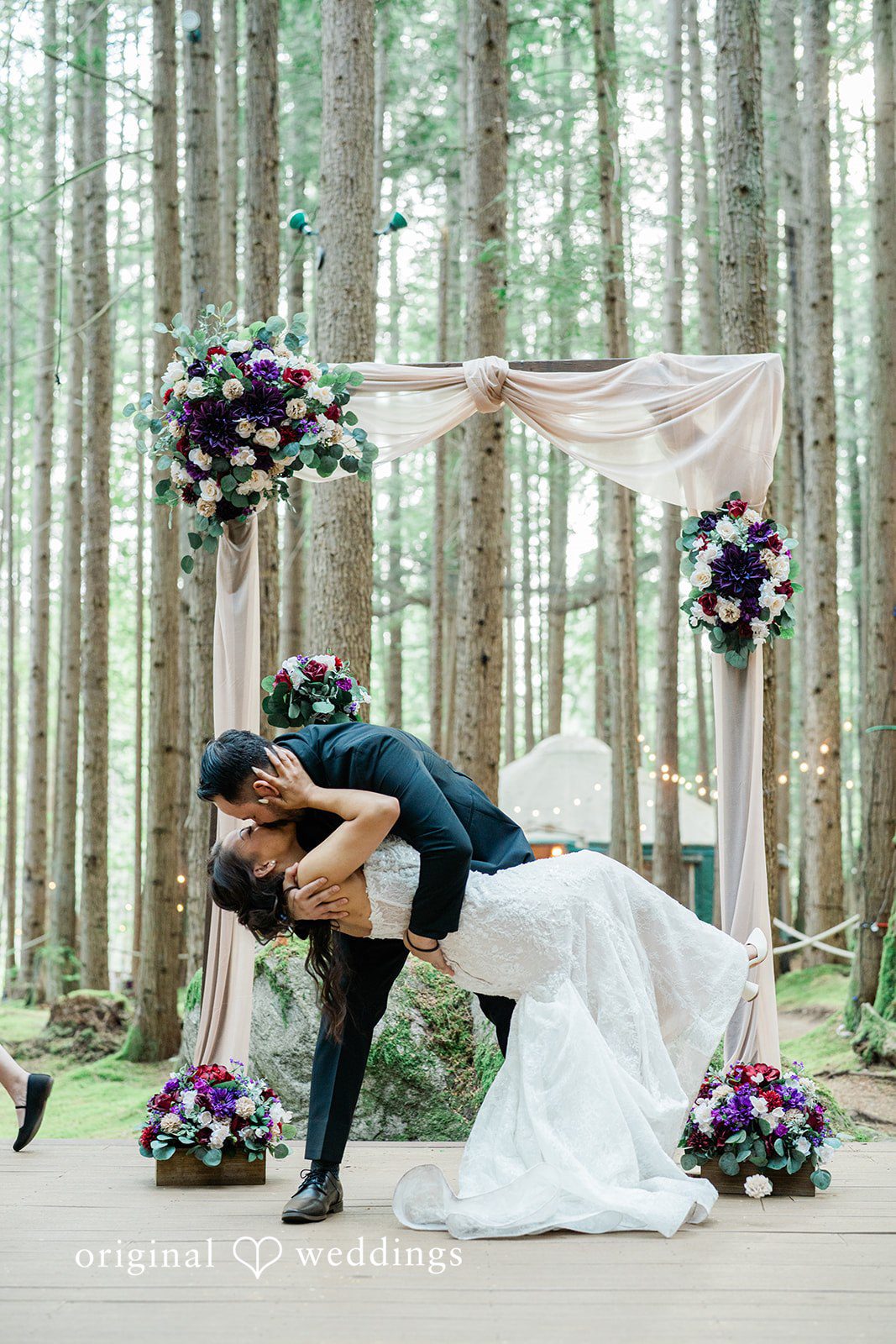 Christopher + Lydia Ceremony dip kiss under the arch at Redmond Emerald Forest