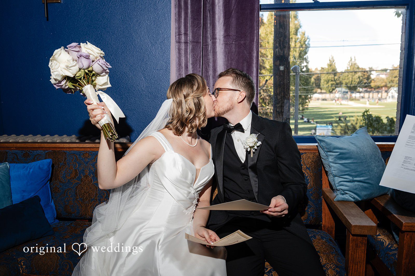 Couple kissing on the sofa by the window