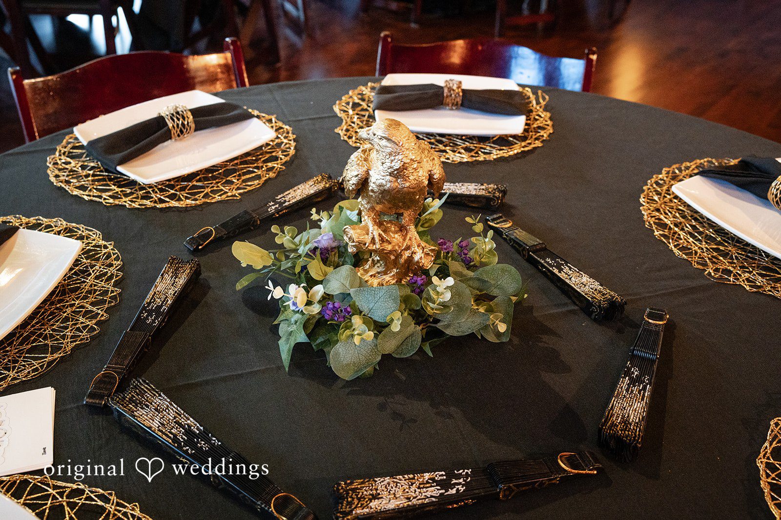 Dark table settings with gold accents at Reverie Ballroom