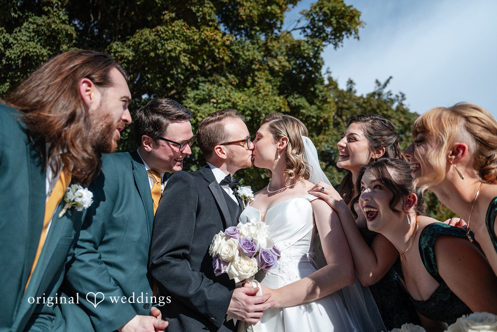 Bride laughing with the groomsmen outdoors