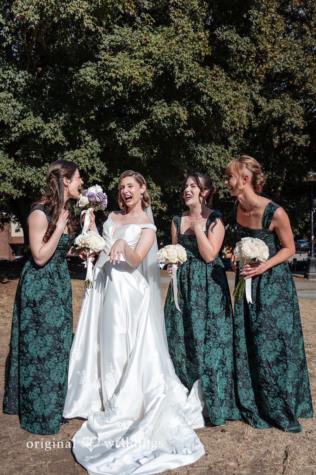 Bride with bridesmaids in emerald dresses outdoors