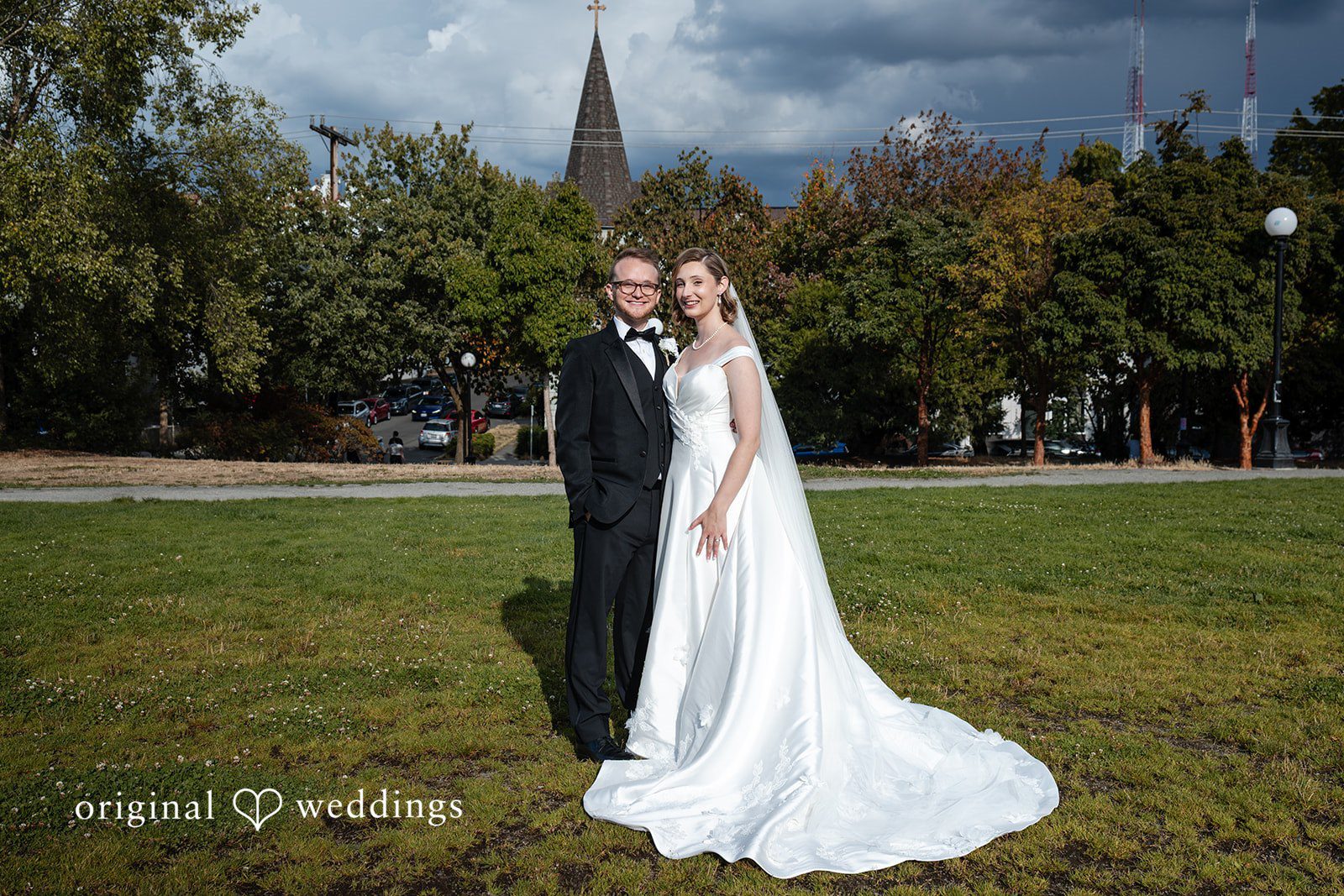 Couple standing on the lawn with church spire behind