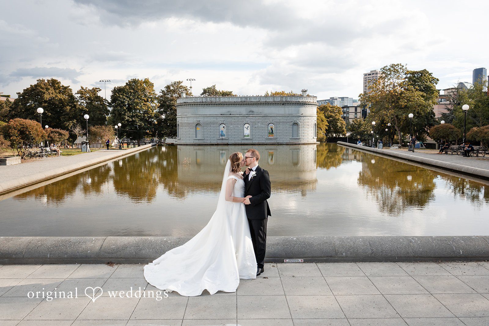 Bride and groom by the reflecting pool, captured by Seattle wedding photographers from Original Weddings