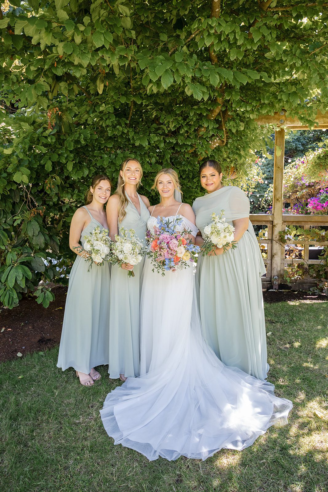 Bride with her bridesmaids in sage dresses at Robinswood House