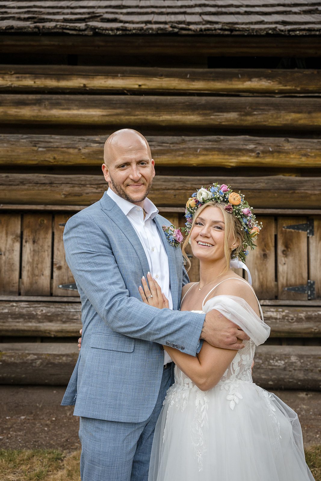 Bride and groom by the log cabin at Robinswood House