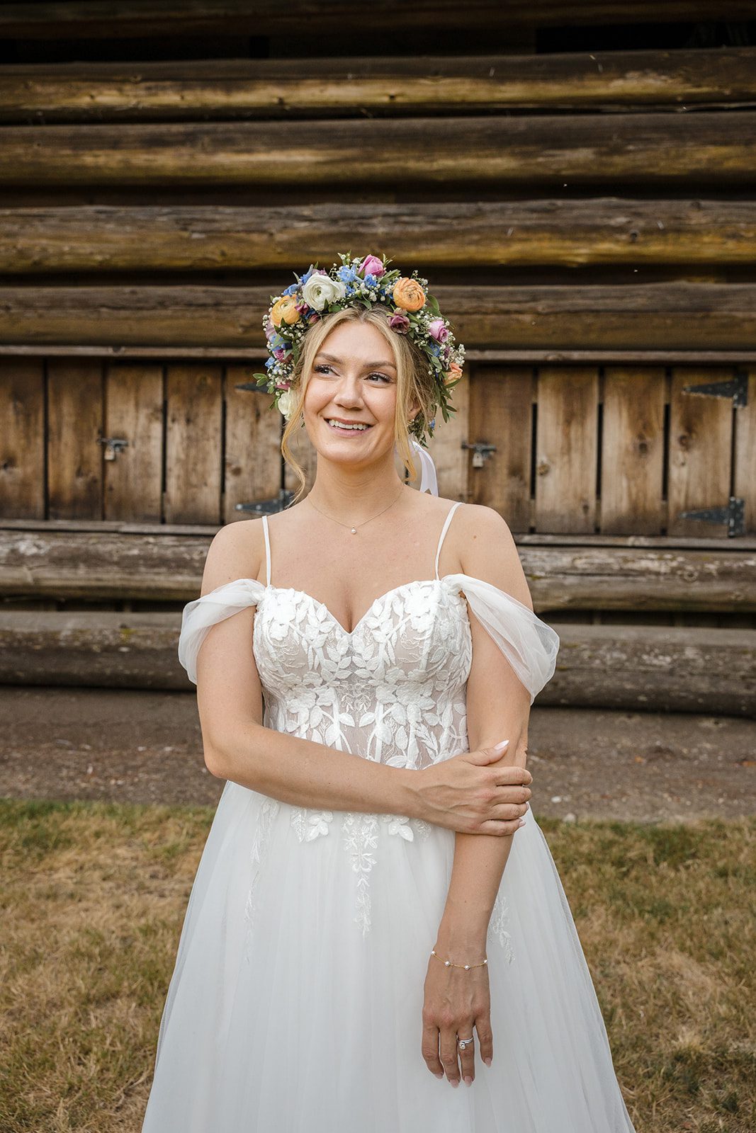 Bride smiling with the groom by the cabin