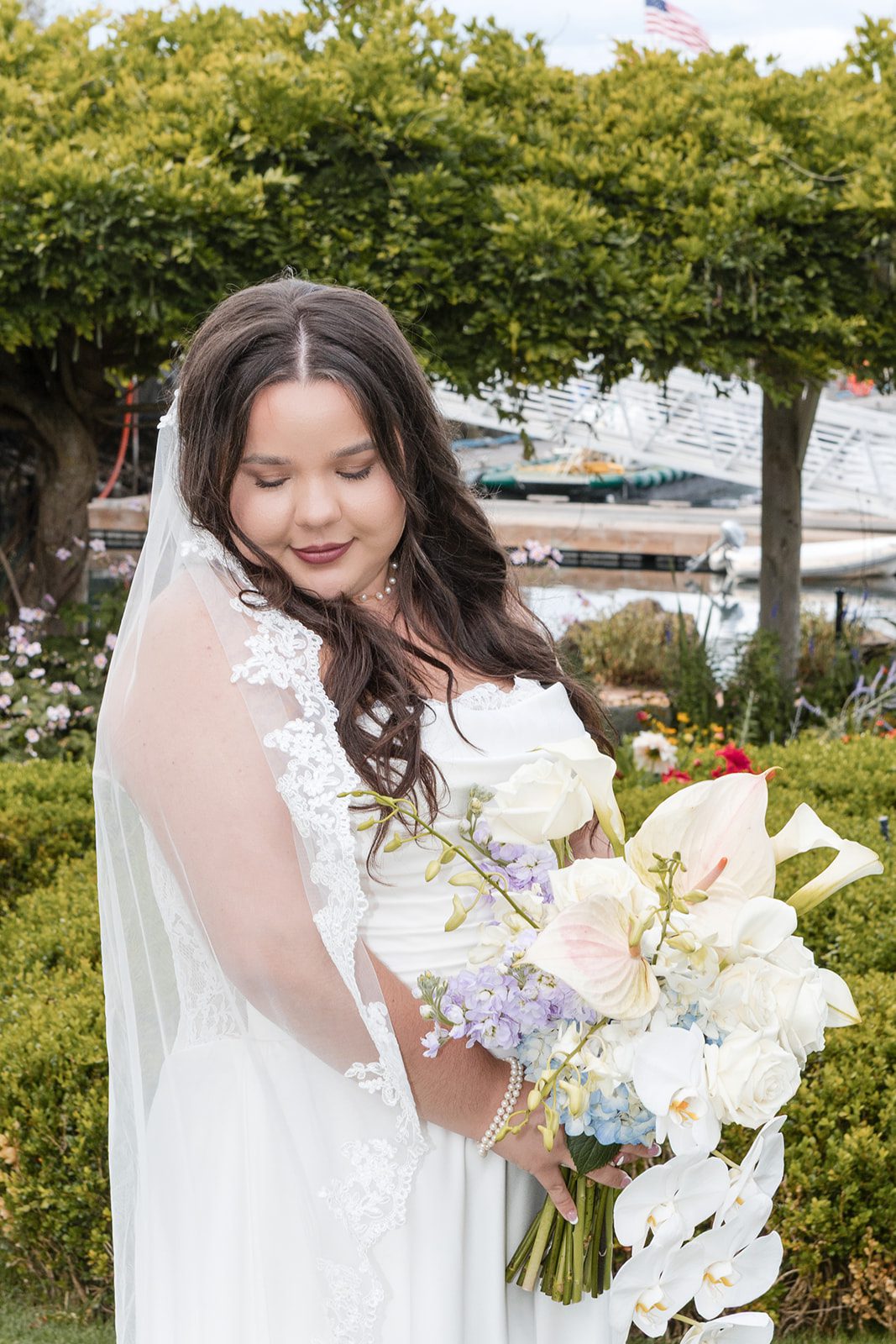 roche-harbor-resort-timeless-seattle-emma-chase-emma-chase-009-13 Bride holding her white bouquet in the gardens at Roche Harbor Resort
