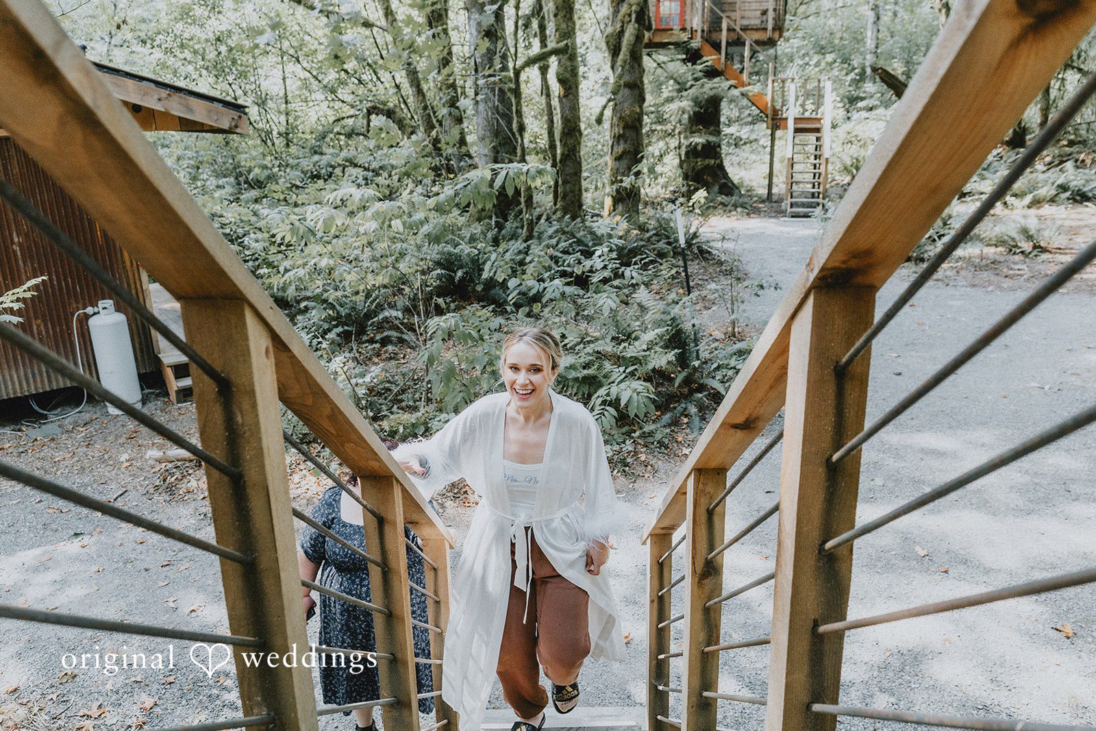 Kailyn + Tony Bride walking down a wooden staircase at Samara Farm