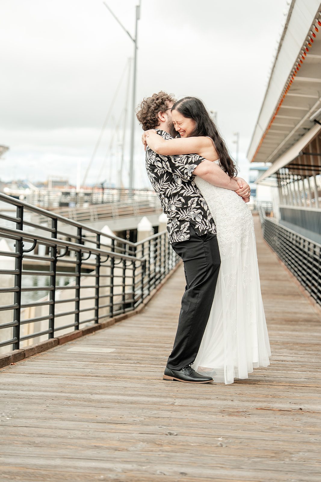 scotts-seafood-grill-bar-timeless-san-francisco-libby-ethan-p010-09 Couple sharing a hug on the waterfront deck, captured by San Francisco wedding photographers