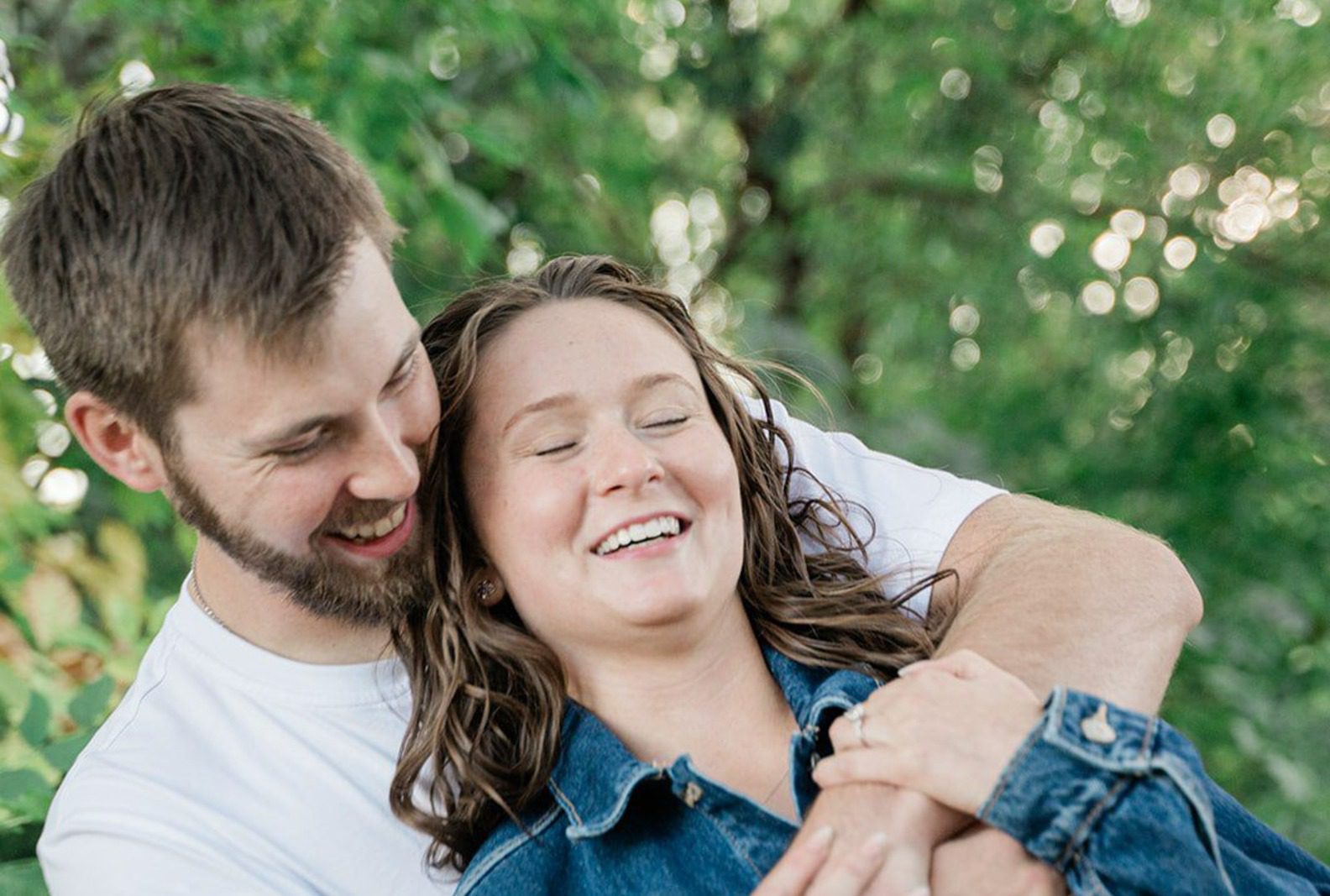 Couple laughing in a hug, captured with Engagement Photography Services from Original Weddings at Silverwood Park