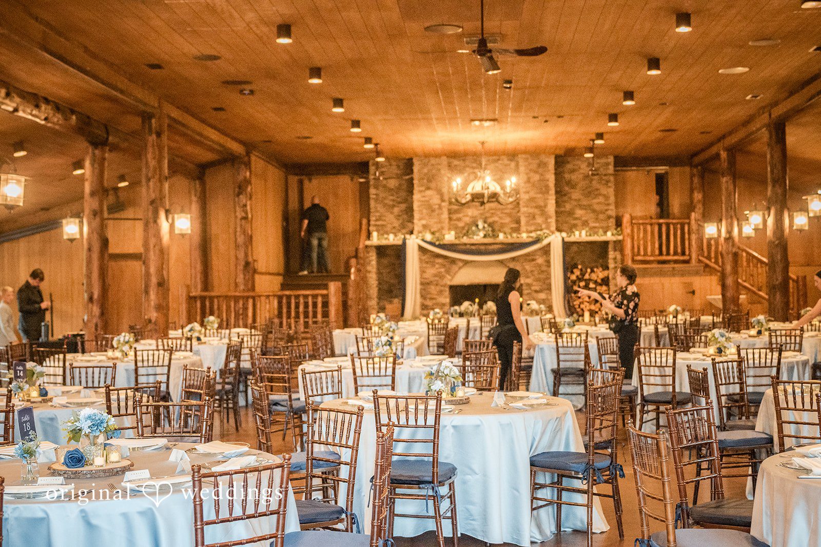 Faith + Brandon Reception hall set with tables and chandeliers at Spruce Mountain Ranch