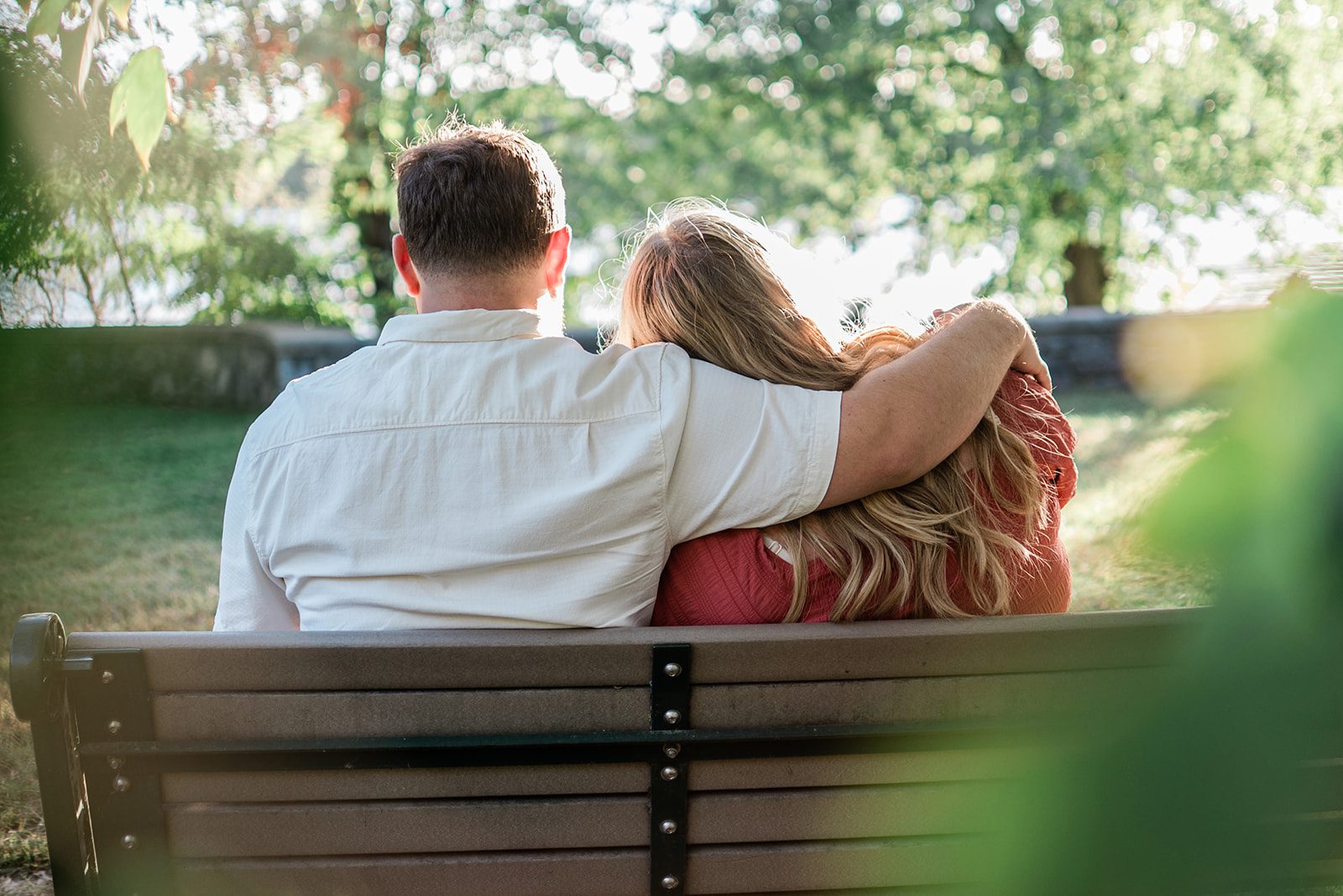 spy-pond-airy-boston-daniel-emily-p002-09 Couple sitting together on the stone wall by the water at Spy Pond