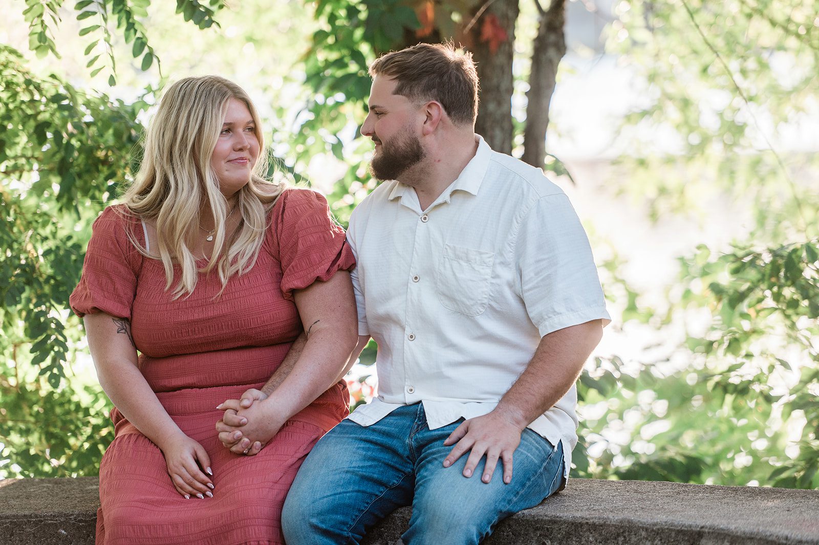 spy-pond-airy-boston-daniel-emily-p004-04 Couple sitting together by the water, captured with engagement photography services from Original Weddings at Spy Pond