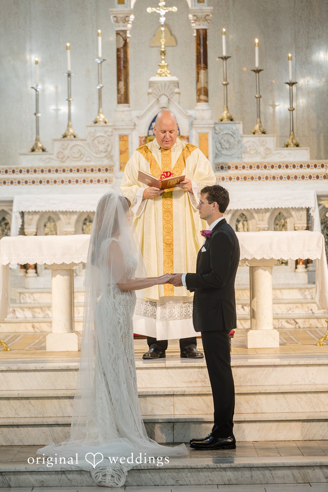 Couple at the altar under the Gothic arches at St John the Evangelist Catholic Church