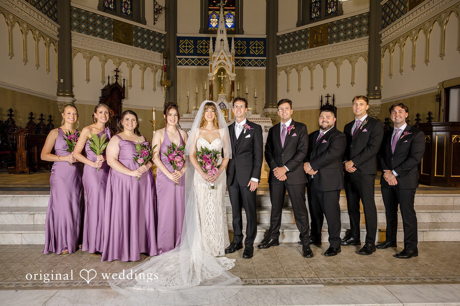 Wedding party in purple and black inside St John the Evangelist Catholic Church