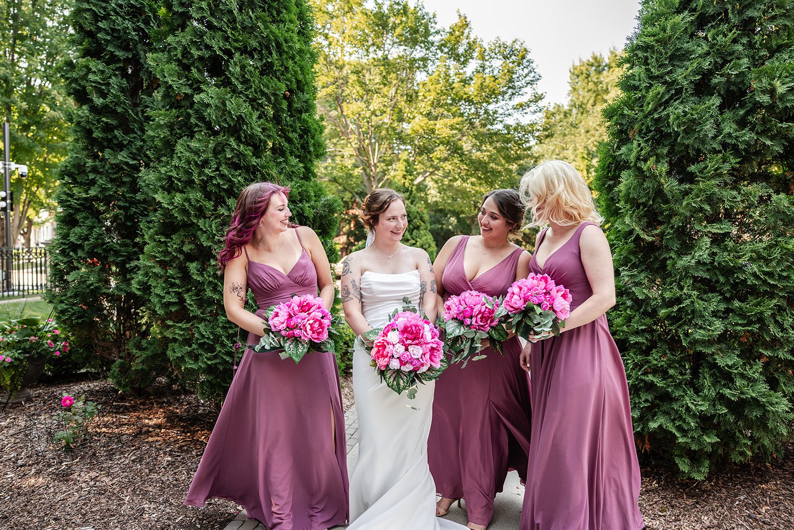 Bride with her bridesmaids holding pink bouquets Bride with her bridesmaids holding pink bouquets