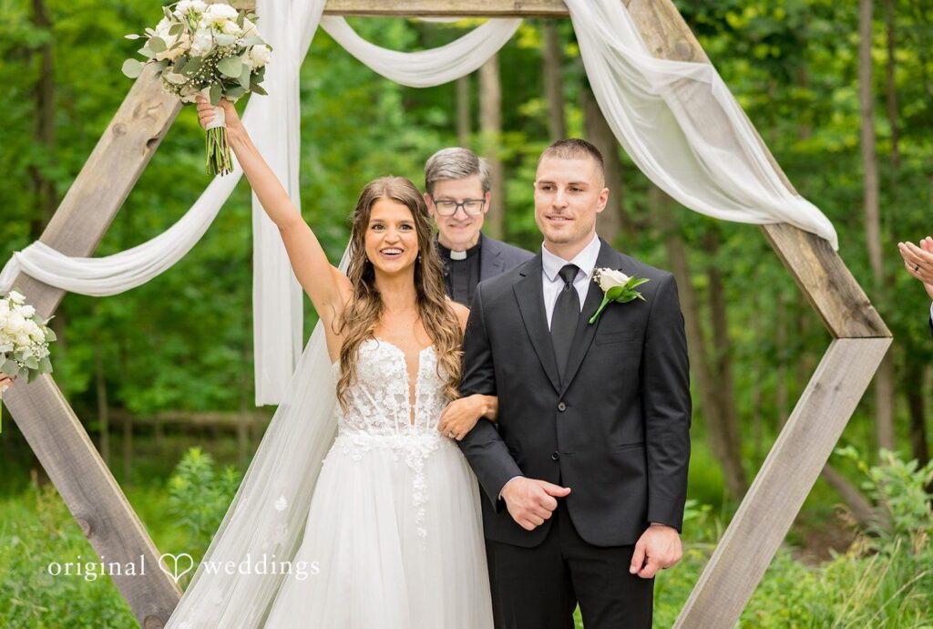 Standing Rock Farms Wedding | Lauren & Tyler 7 Bride and groom smiling under the wooden arbor, captured by Cleveland wedding photographers from Original Weddings at Standing Rock Farms