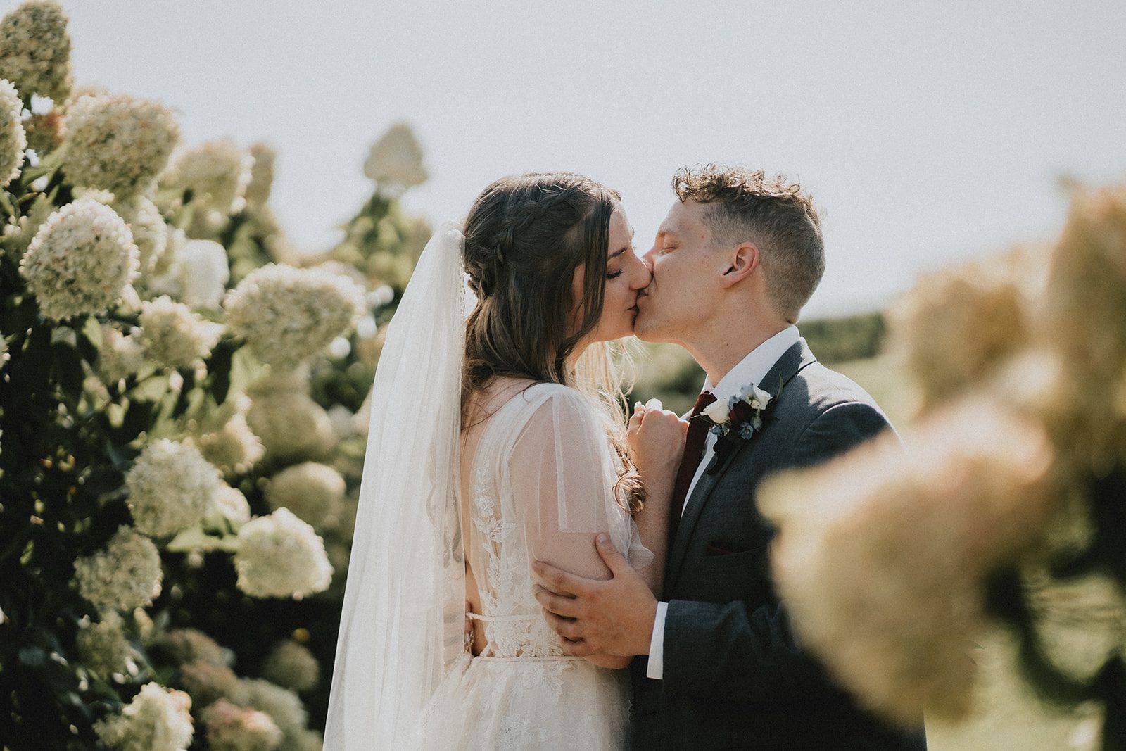 stone-tower-winery-rustic-washington-dc-nikkie-tyler-p035-08 Couple kissing beside the flowers