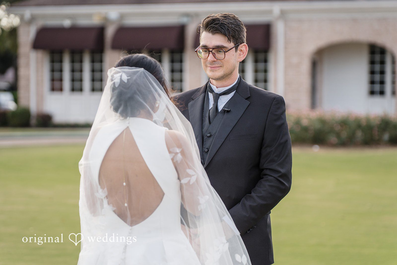 Nicholas + Nisha Bride and groom posing together with the bride's veil draped over her back.