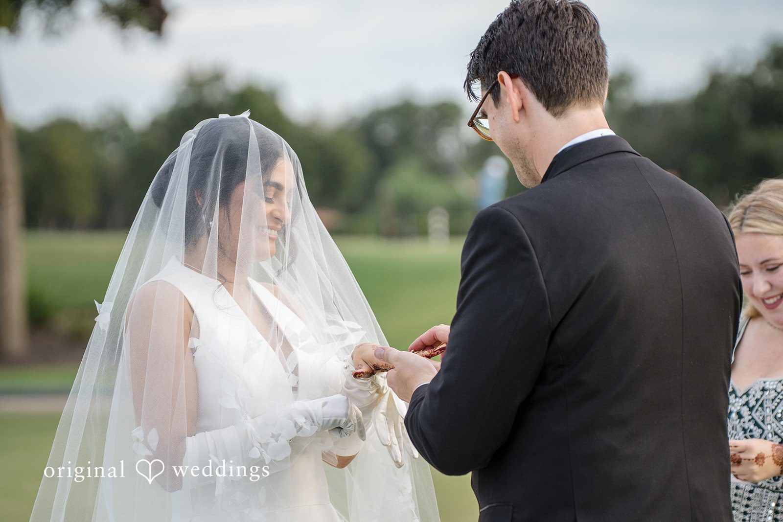 Nicholas + Nisha Groom placing a ring on the bride's finger during the ceremony.