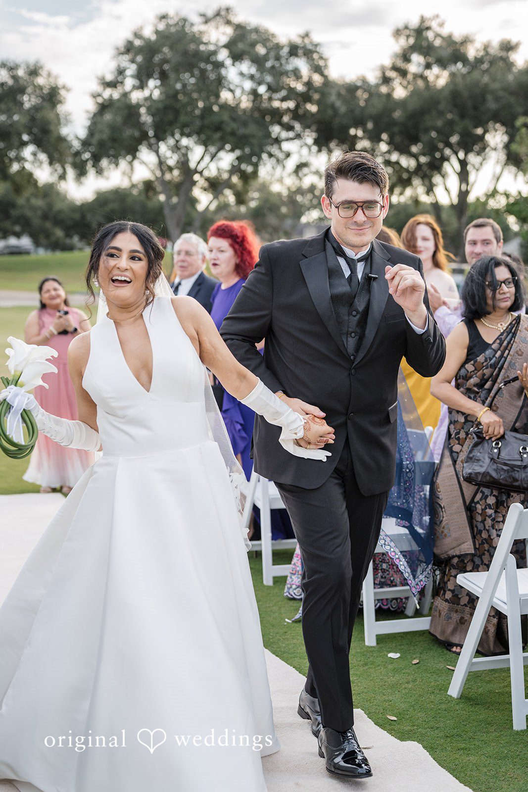 Nicholas + Nisha Newlyweds celebrating and walking through a crowd of cheering guests.