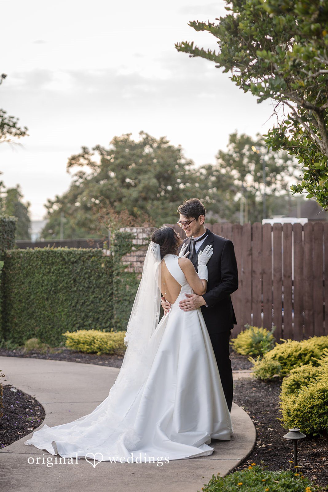 Nicholas + Nisha Bride and groom sharing a close moment surrounded by greenery.