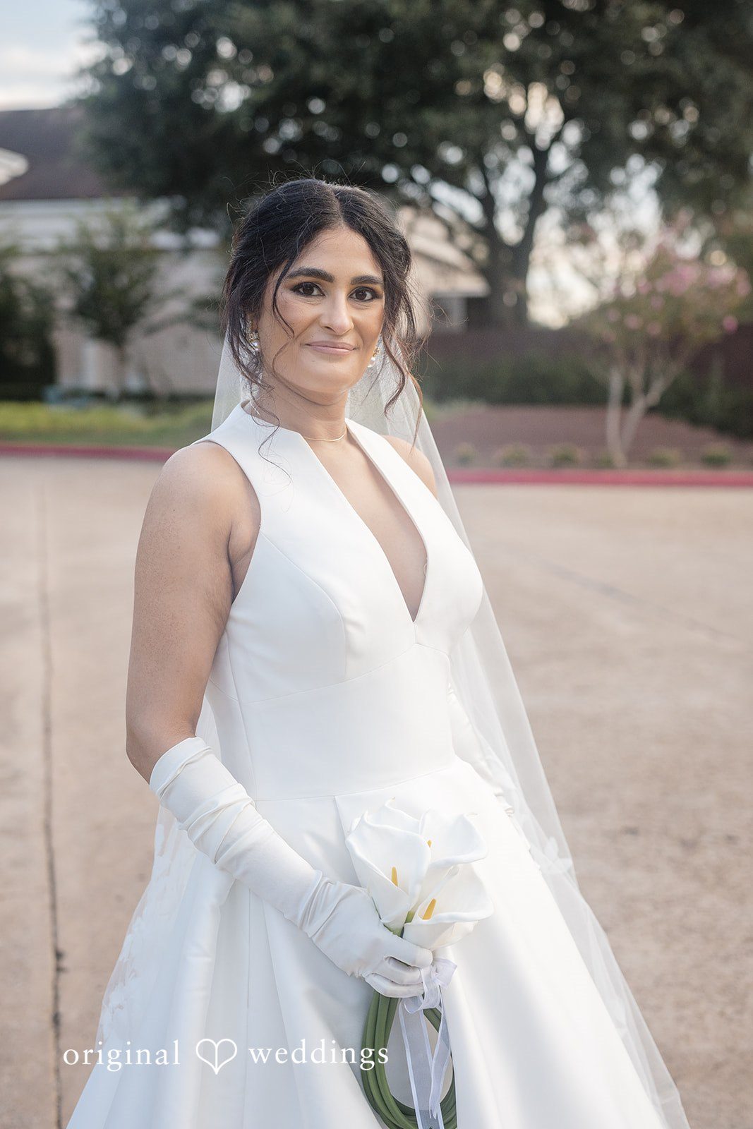 Nicholas + Nisha Portrait of a bride wearing a white gown and a long veil.