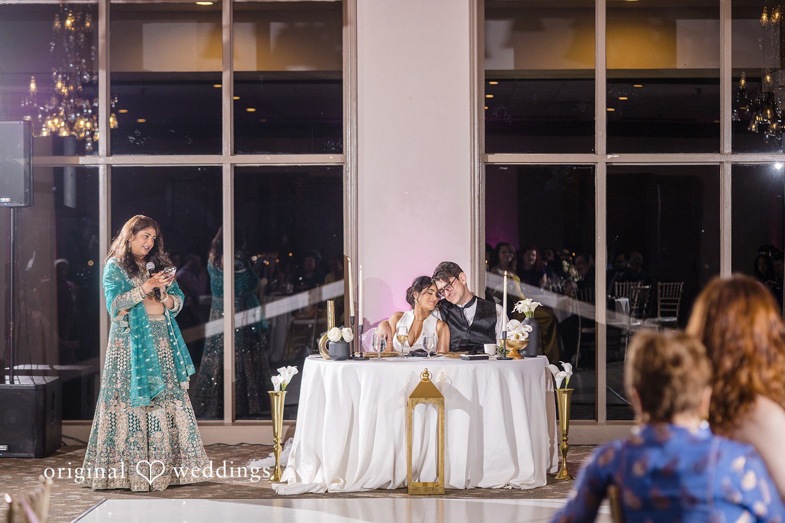 Nicholas + Nisha Wedding reception setup featuring a decorated table with lighting.