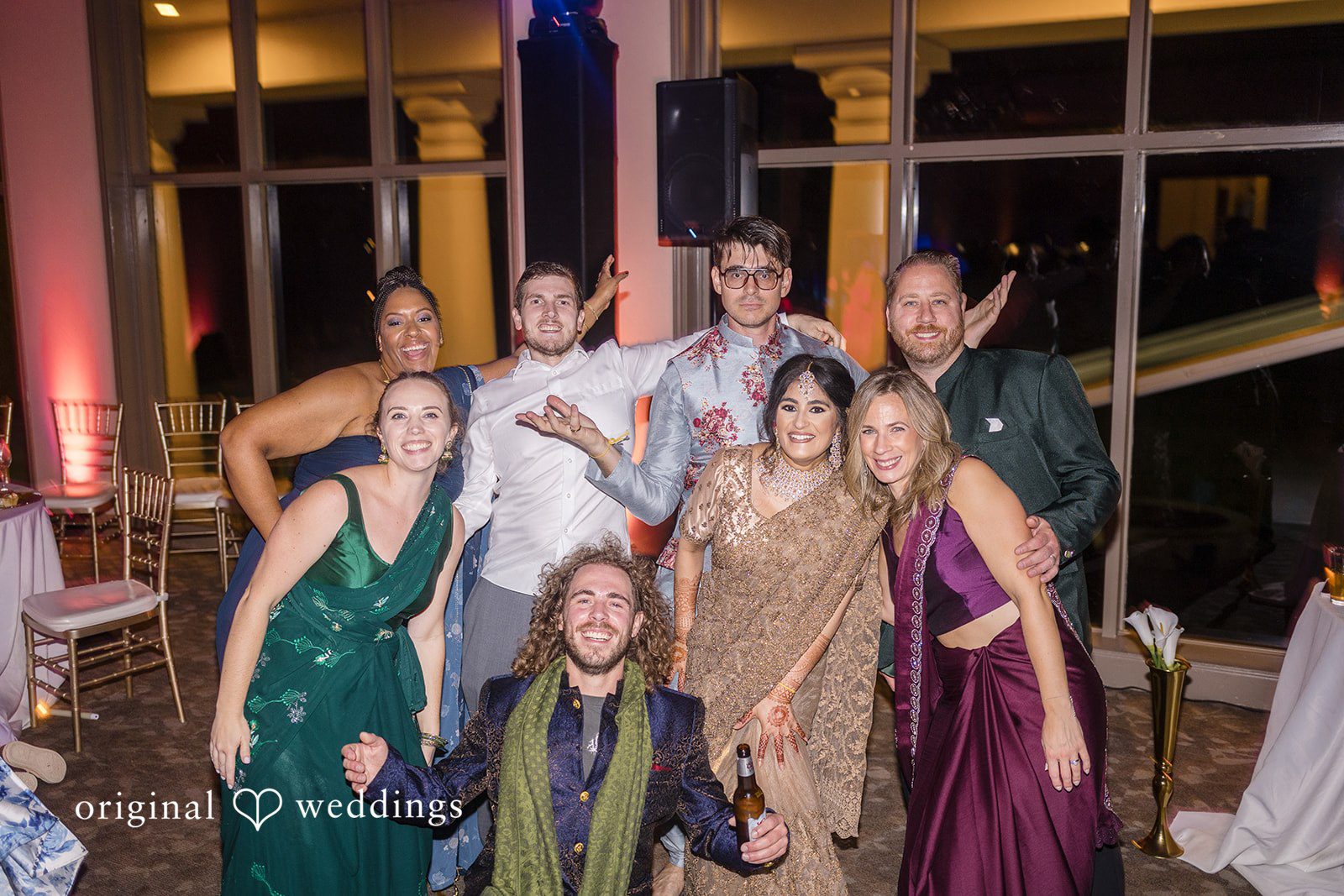 Nicholas + Nisha Group of wedding guests posing and celebrating together on the dance floor.