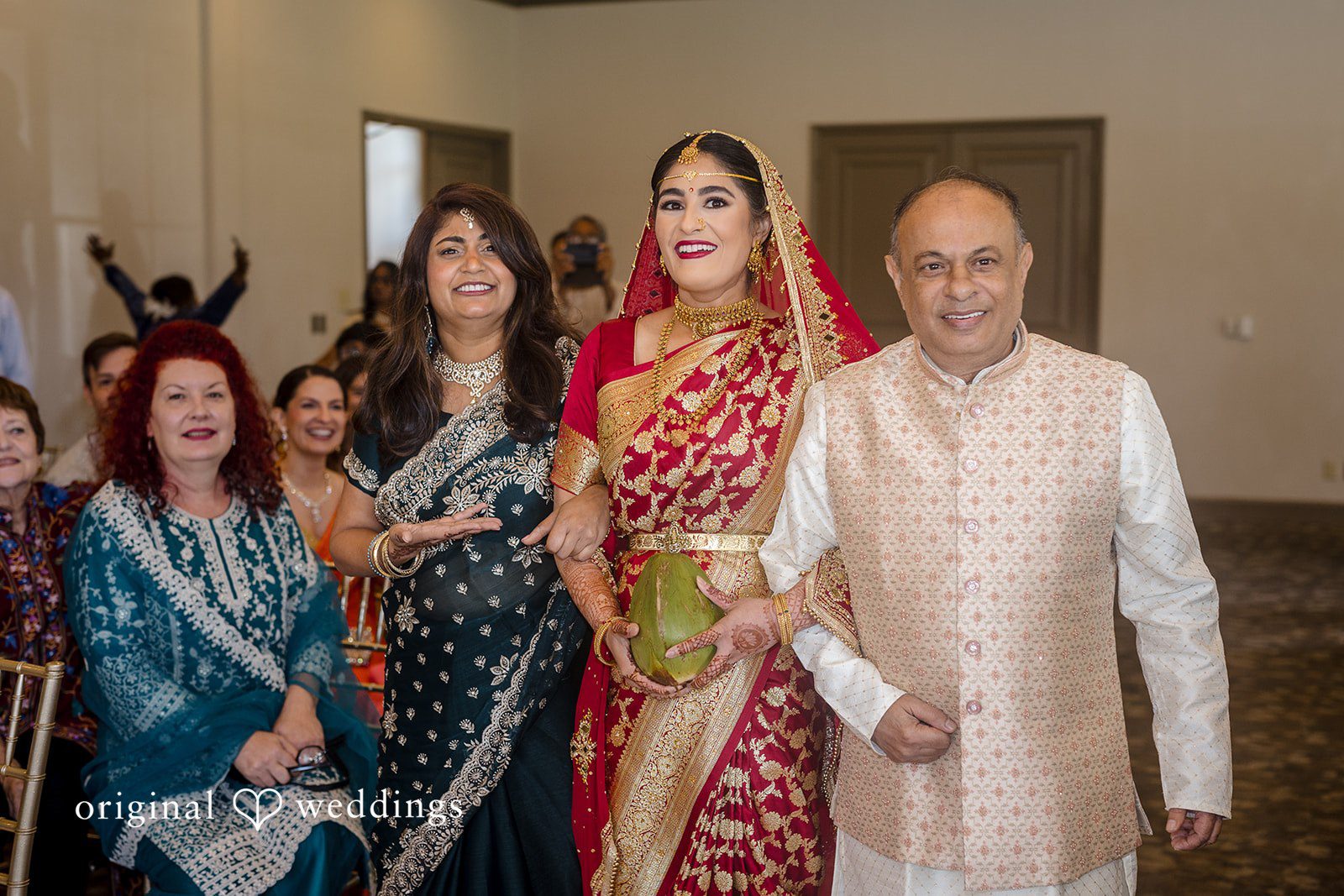 Nicholas + Nisha Group of wedding guests posing together in elegant traditional attire.