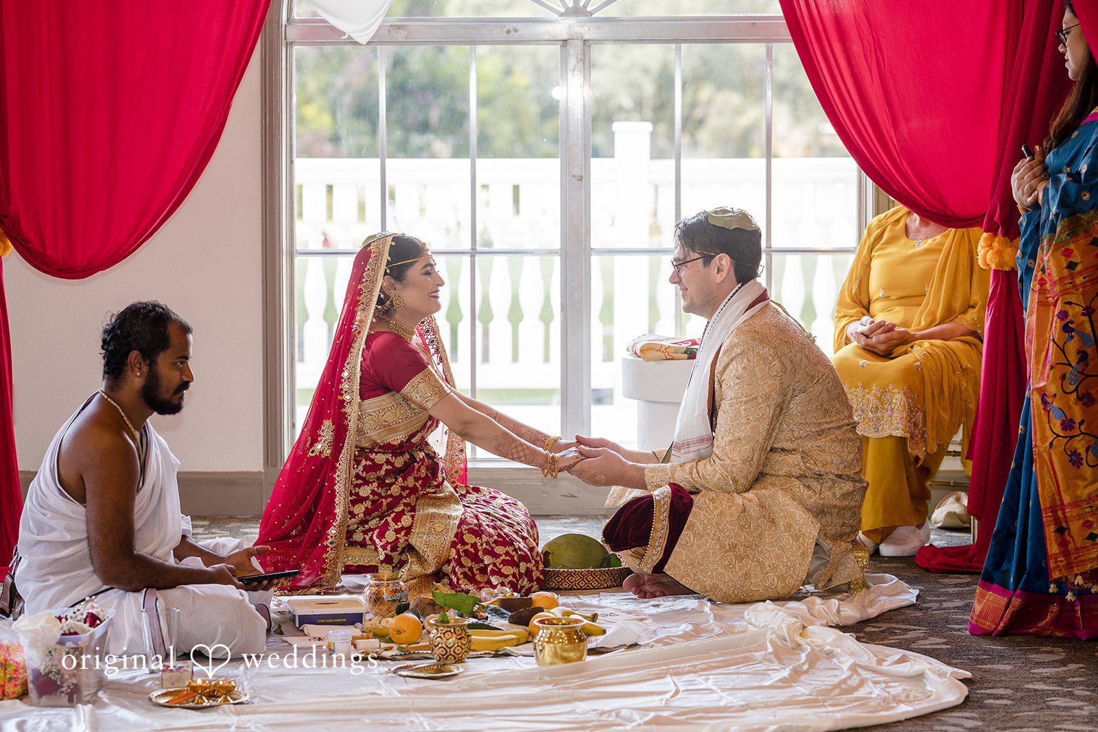 Nicholas + Nisha Wedding ritual taking place with participants seated on the floor.