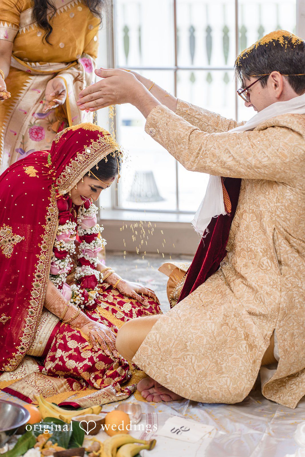 Nicholas + Nisha Groom placing a garland or performing a ritual with the bride.
