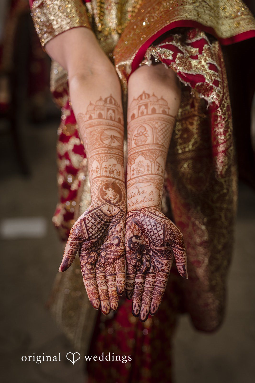 Nicholas + Nisha Detailed view of intricate henna designs applied to a person's hands.