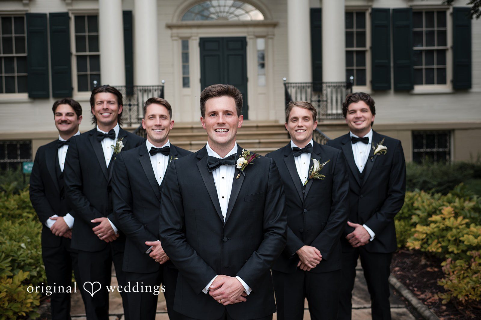 Macy + Nolan Groomsmen in black tuxedos standing together.